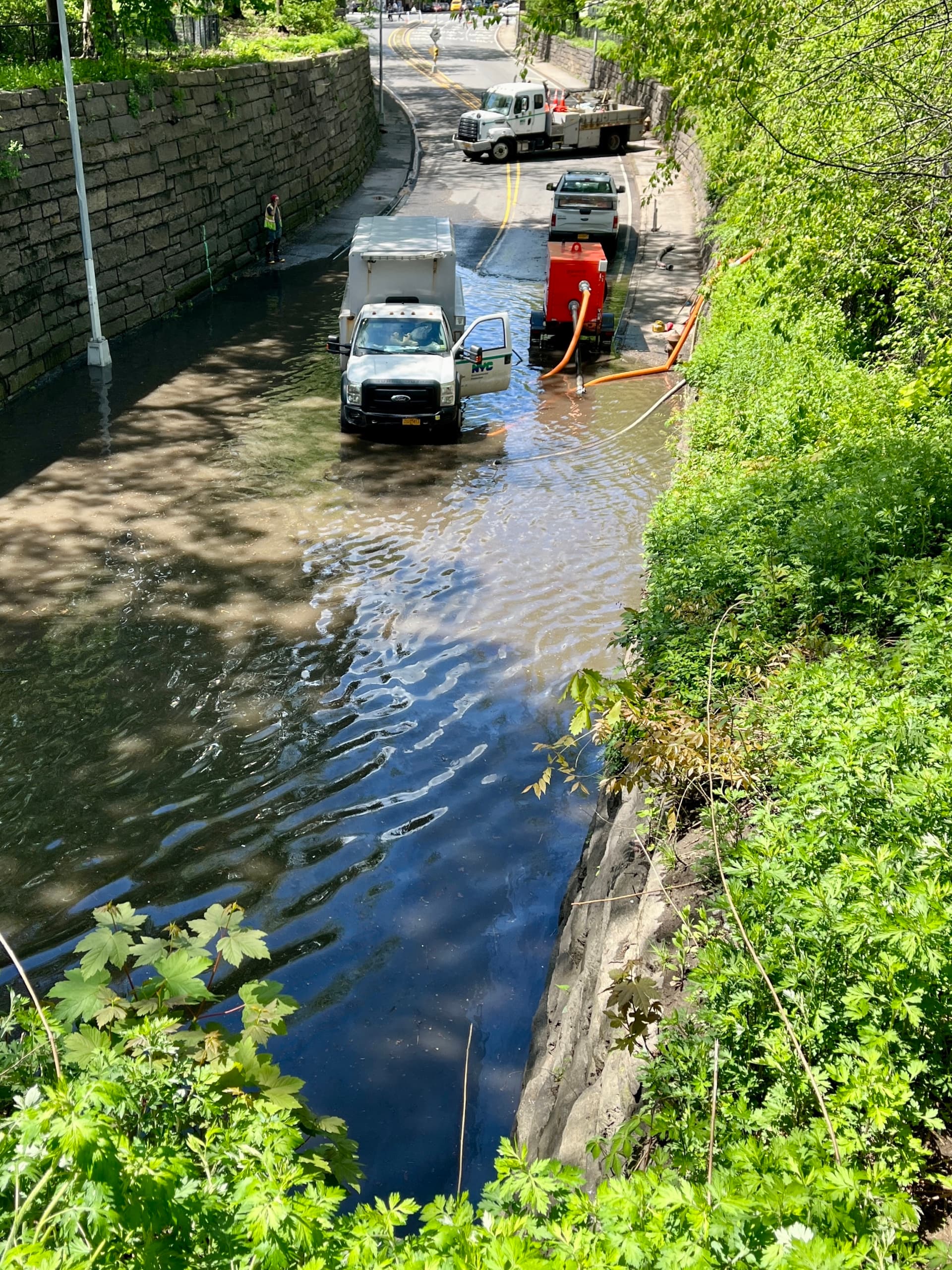 City trucks attempt to dewater a flooded section of the Central Park Transverse